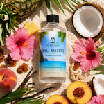 Bottle of Bali Reserve fragrance oil surrounded by tropical fruits and flowers on sand