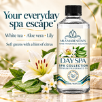 A bottle of Mila Marie Scents Day Spa home fragrance oil stands on a marble surface beside white lilies, aloe vera slices, and small flowers, with promotional text reading 'Your everyday spa escape' and 'White tea • Aloe vera • Lily.'.