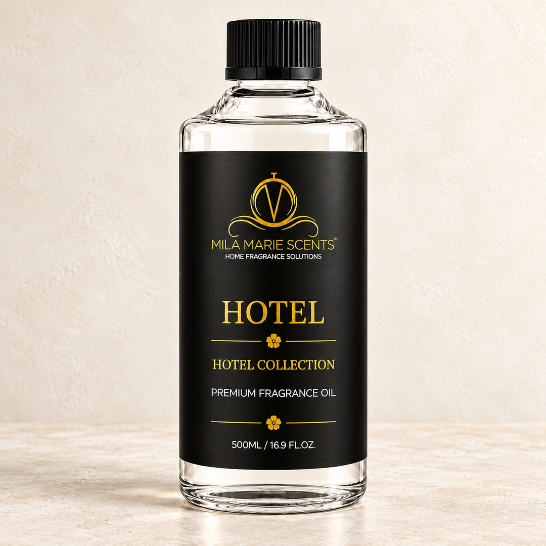 A 500ml bottle of Milá Marie Scents Hotel Collection fragrance oil, featuring a clear glass bottle, black cap, and a black label with gold lettering, set against a textured beige background.