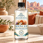 A bottle of Mila Marie Scents 'Sedol Sol' spa collection fragrance oil stands on a stone countertop in a warm, cozy living room setting with a blurred background of a couch, pillows, and a desert landscape.
